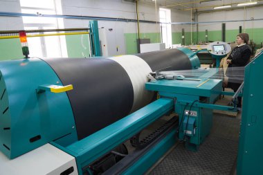 Bakü, Azerbaycan, 20 Şubat: Tekstil endüstrisi için renkli ipek ipliği üretmek için arka planda makine donanımı bulunan yakınlardaki fabrikada çalışan kadın işçiler.