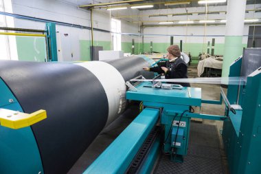 Bakü, Azerbaycan, 20 Şubat: Tekstil endüstrisi için renkli ipek ipliği üretmek için arka planda makine donanımı bulunan yakınlardaki fabrikada çalışan kadın işçiler.