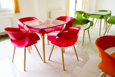 Parlak kırmızı, yeşil masalı ve plastik sandalyeli iç kafe..