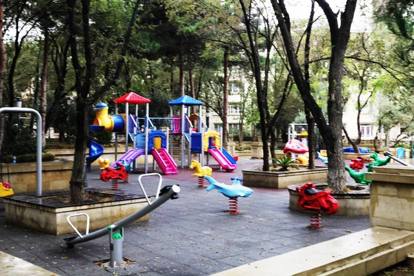 Childrens spelen huis in een park met kleurrijke schommels. — Stockfoto