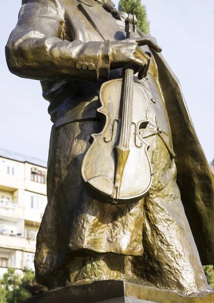 Ancienne statue en bronze dans un parc public de musiciens tenant un violon — Photo