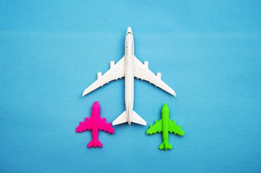 Mavi arka planda minyatür oyuncak uçak yatağı ve seyahat yaratıcı kavramlar. Boşluğu kopyala