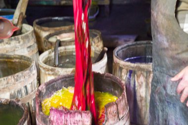 Erkek usta doğu, Türk ipek kadın eşarpları boyuyor, boya fıçısında şallar, doku, arka plan, desen