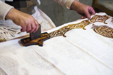 Erkek usta oryantal, Türk ipek kadın şalları, doku, arka plan, desen üzerine desenler koyar. Kadın başörtüsü, şal. Parlak renkler. Şal desenli. Hint teması. Giysiler için kumaş Kumaş 100 ipek.