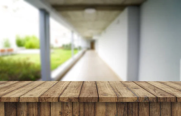 Tablero marrón de madera contra el pasillo borroso, el pasillo y el patio de la casa.Para el montaje o el diseño de la exhibición del producto es la llave visual del diseño. —  Fotos de Stock