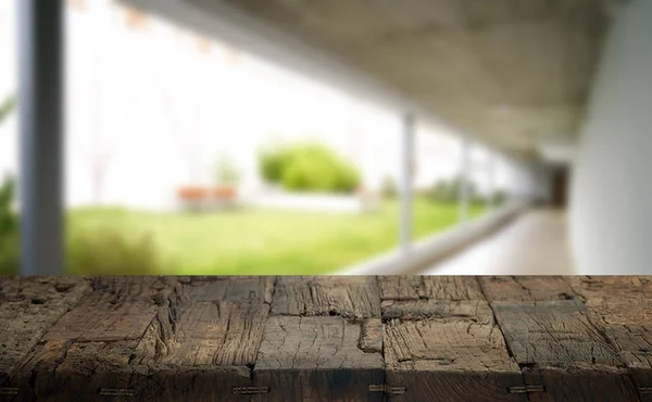 Wooden brown table top against the blurred corridor, passage and courtyard of the house .For product display montage or design is the key visual of the layout. — Stock Photo, Image