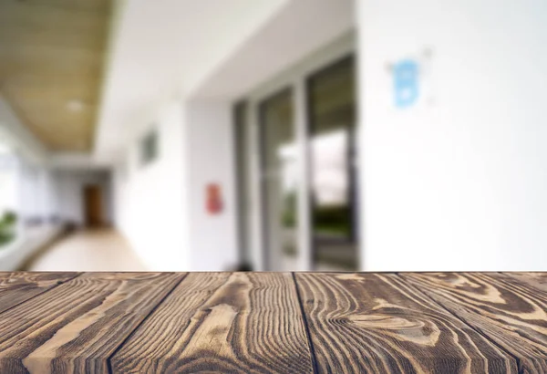Tablero marrón de madera contra el pasillo borroso, el pasillo y el patio de la casa.Para el montaje o el diseño de la exhibición del producto es la llave visual del diseño. —  Fotos de Stock
