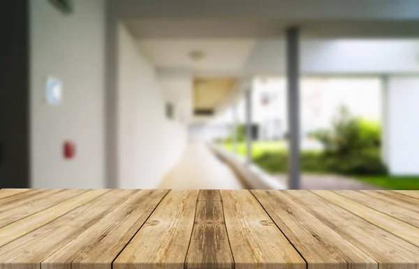 Tablero marrón de madera contra el pasillo borroso, el pasillo y el patio de la casa.Para el montaje o el diseño de la exhibición del producto es la llave visual del diseño. —  Fotos de Stock