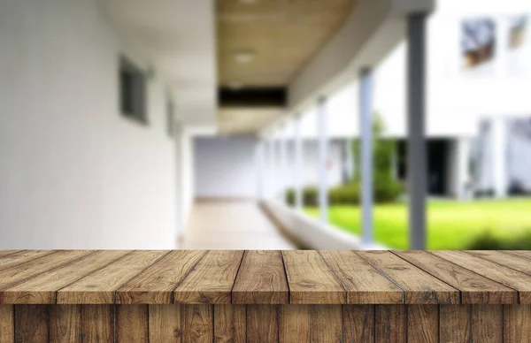 Tablero marrón de madera contra el pasillo borroso, el pasillo y el patio de la casa.Para el montaje o el diseño de la exhibición del producto es la llave visual del diseño. —  Fotos de Stock