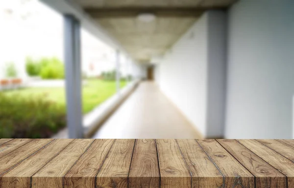 Tablero marrón de madera contra el pasillo borroso, el pasillo y el patio de la casa.Para el montaje o el diseño de la exhibición del producto es la llave visual del diseño. —  Fotos de Stock