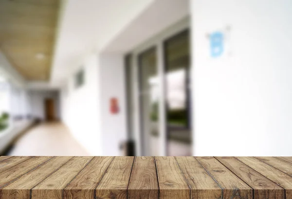 Tablero marrón de madera contra el pasillo borroso, el pasillo y el patio de la casa.Para el montaje o el diseño de la exhibición del producto es la llave visual del diseño. —  Fotos de Stock