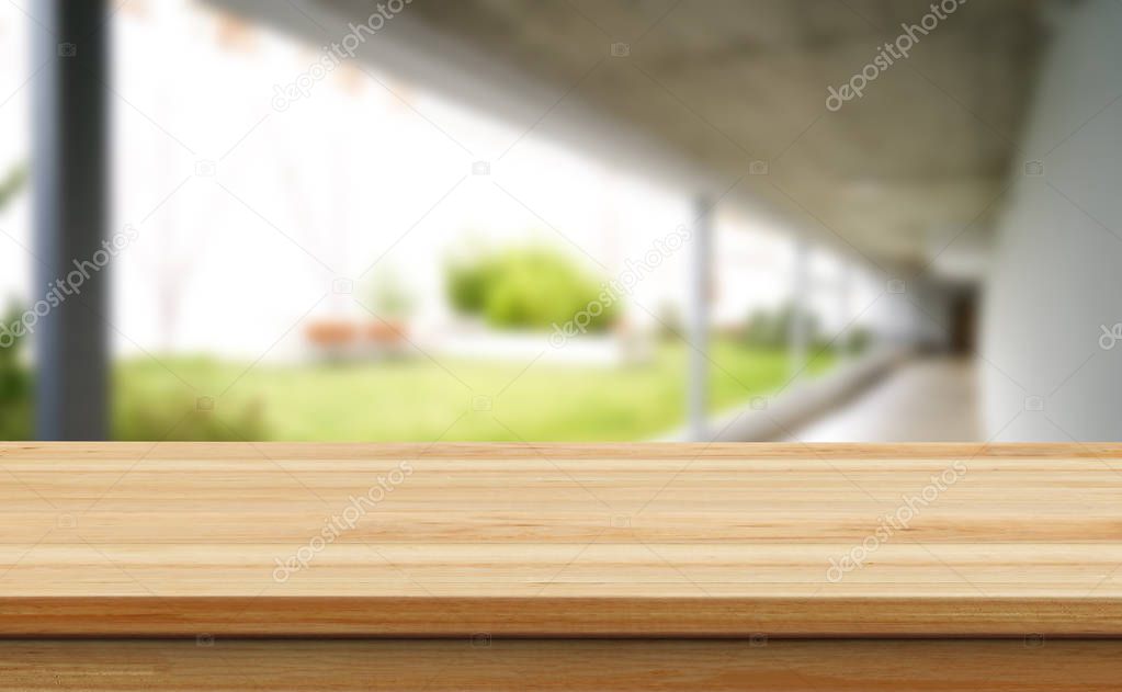 Wooden brown table top against the blurred corridor, passage and courtyard of the house .For product display montage or design is the key visual of the layout.