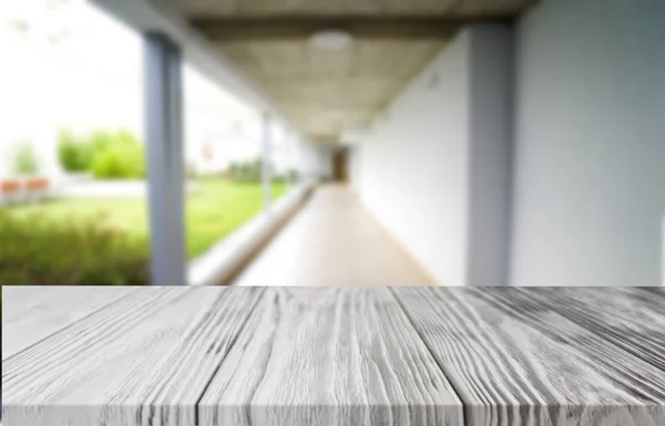 Wood white table top on blur building hall background form office building.For montage product display and design key visual layout.