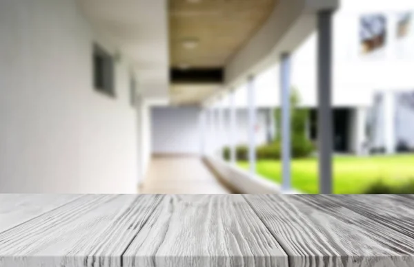 Tablero blanco de madera de la tabla en el edificio borroso pasillo fondo forma oficina building.For montaje producto exhibición y diseño clave diseño visual . —  Fotos de Stock