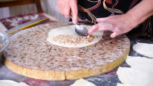Жінка готує турецькі, східні, національні пироги з м'яса, гутаби на кухні.. — стокове відео