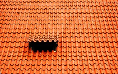 Bir çatı alanı penceresinin çatı işi: kırmızı kiremitlerde velux stili çatı penceresi.