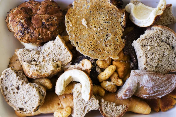 Pile of many slices of stale bread and other stale baked goods. Tossing breads and buying too much bread without the need. Or stocks of rusks for a poor family. Copy space for text. Close-up