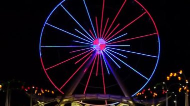 Dönme dolap gece çalışır, ışıklar ile aydınlatılmış, büyük atlıkarınca renkli çalışan ışıklar.