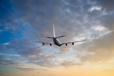 Gün batımında dramatik bulutların üzerinde uçan uçak