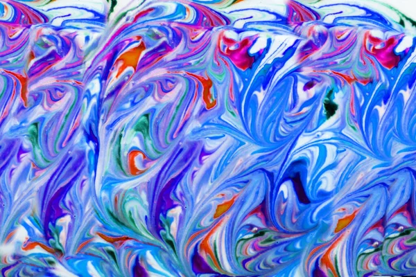 Colorful liquid paints mixed together creating modern abstract