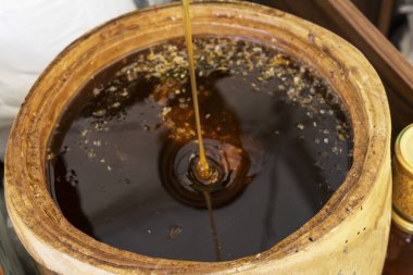 Bal kaşığı taze kokulu bal fıçısına gömülü. Yakın plan.