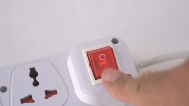 人間の指のクローズアップショットは、電源コンピュータに拡張コードの電源ボタンをオンにします。背景としての電源オフボタンの概念 — ストック動画