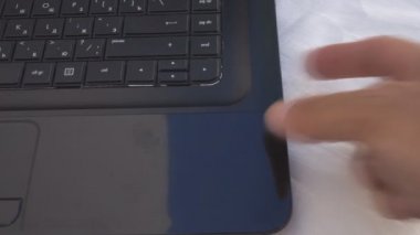 Bir adamın eli bilgisayarın sürücüsünü açar ve diski yerleştirir.