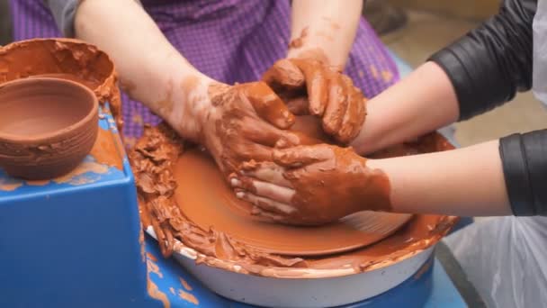 Händer av krukmakare lär barnet hur man gör krukor. Koncept - överföring av erfarenheter, — Stockvideo