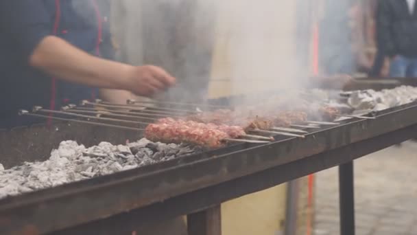 Mãos de um homem a rodar os espetos. Kebab Shish. Pedaços de carne de porco ou cordeiro sendo fritos em uma grelha de carvão. Fritar pedaços de carne grelhados durante o resto. — Vídeo de Stock