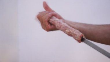 Baharatlı sosis, marine edilmiş tavuk ve sığır eti karışımı, ızgarada kızarmadan önce çiğ et parçaları dizen adam. Barbekü hazırlığı..