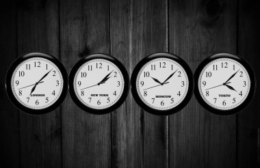 İş yerinin siyah duvarındaki duvar saatleri dünyanın farklı başkentlerinin zamanlarını gösteriyor. Farklı zaman dilimlerine sahip duvar saatleri