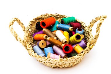 Beyaz arka planda örgü ipliği topları olan hasır sepet, kapat.