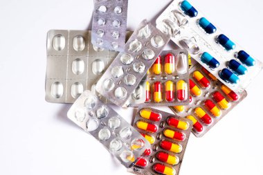 Beyaz arka planda bir sürü ilaç hapı var.