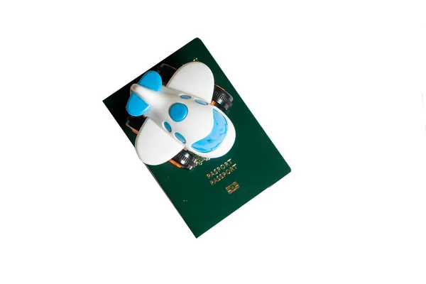 Klein Speelgoedvliegtuigje Bovenop Groene Paspoorten Een Witte Achtergrond — Stockfoto