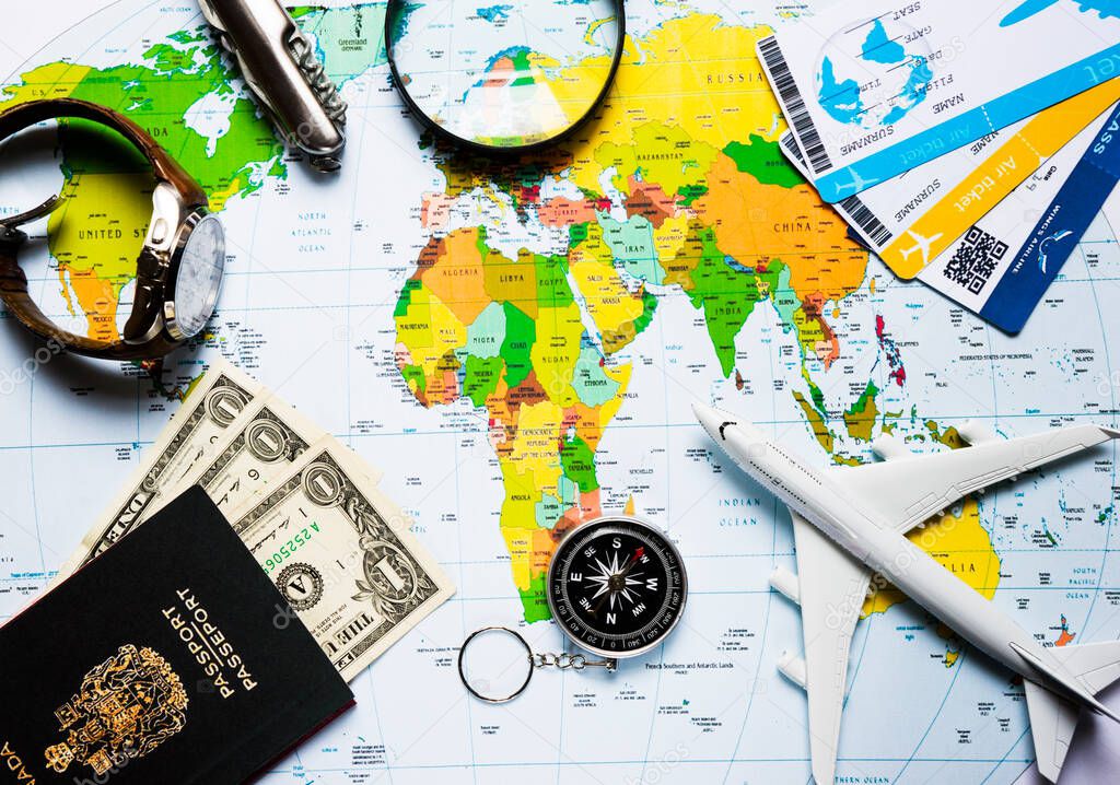 plane, globe, passport, dollars, compass, clock, magnifier knife on the world map travel turizm concept