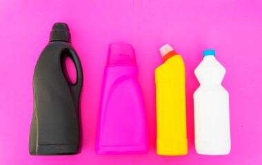 Kırmızı arka planda kimyasallar için evle birlikte çok renkli plastik şişeler..