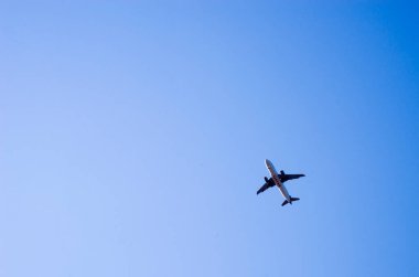 Yolcu uçağı açık mavi gökyüzüne doğru uçar