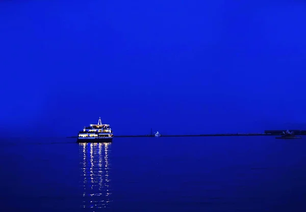 a pleasure boat floats in the sea at night