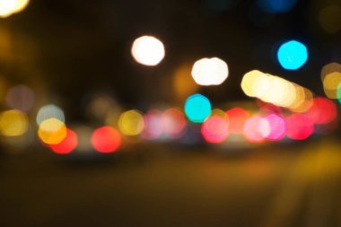 Islak bir arka planda trafik sıkışıklığında ışığın soyut gölgesi, bulanık çözünmüş araba ışıkları.