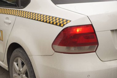 Beyaz taksi caddede dikiz aynasından duruyor.