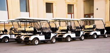 Güneşli bir bahar gününde arka arkaya golf arabaları ya da golf arabaları..