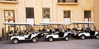 Güneşli bir bahar gününde arka arkaya golf arabaları ya da golf arabaları..