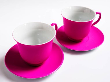 Beyaz arka planda iki pembe seramik kupa, izole.