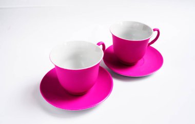Beyaz arka planda iki pembe seramik kupa, izole.