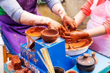 Usta seramist, öğrencilere öğretiyor. Usta seramist, öğrencilere öğretiyor. Zanaatkar eller çömlek kasesi yapıyor. Çömlekçi çarkında çalışan kadın. Aile atölyesi çömlek heykelini kilden yapıyor..
