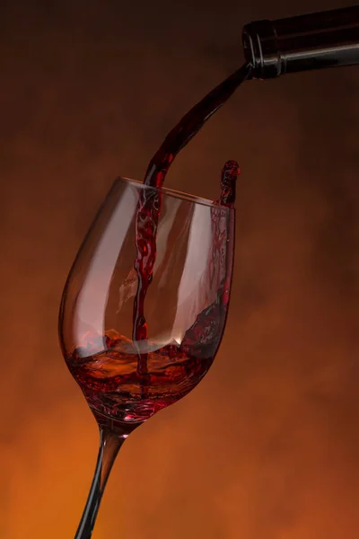 Бутылка Наполняющая Стакан Красным Вином Красном Фоне — стоковое фото