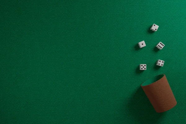 在绿色布上的骰子和骰子杯 3D说明 — 图库照片