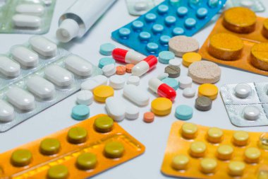 Beyaz arka planda farklı renkte haplara yakın