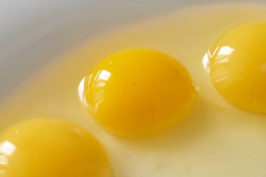 Üç kırık bıldırcın yumurtası shalow beyaz tabak içinde paslı siyah arka plan üzerine bir makro bakış. Kavramı sağlıklı nutritions ve doğal mutfağı