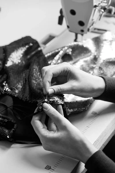 Seamstress woman sewing sequins on the party dress. Tailor atelier - handmade exclusive clothes making and repair, private business, creative occupation concept